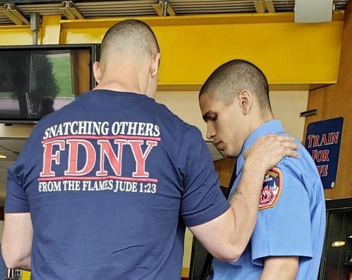 one firefighter praying over another